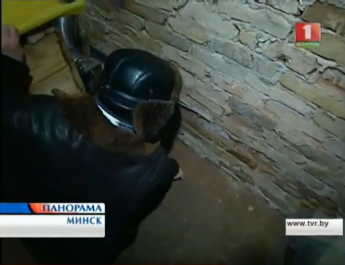 Вячеслав Гнут показывает место в подвале где появилась "светящаяся змейка".      
