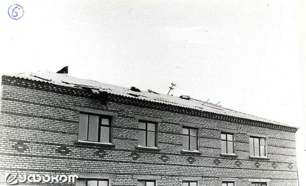 Фото 6. Тот же дом со стороны дороги. На крыше видны следы от воздействия феномена – погнутая стойка электропроводов, свисающий лист толя. (Фото Макарова В.Н.).