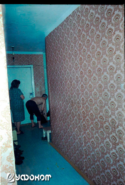 Ф13 – снимок в квартире Кисляковых: вид из ванной на коридор. На заднем плане у двери на кухню видны хозяин квартиры и его жена.