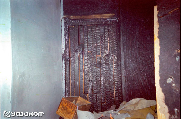 Ф10А – снимок в коридоре этой квартиры. Прямо видна обгоревшая дверь стенного шкафа. Внизу видно пламя горящей газеты.