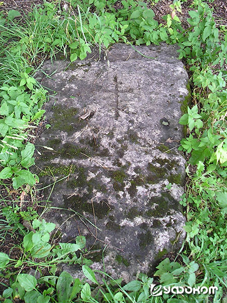 Рис. 3. Высеченный крест на плите, аналогичной Труворову камню. Находится возле Никольской церкви на Труворовом городище. Фото автора, 2019 год.