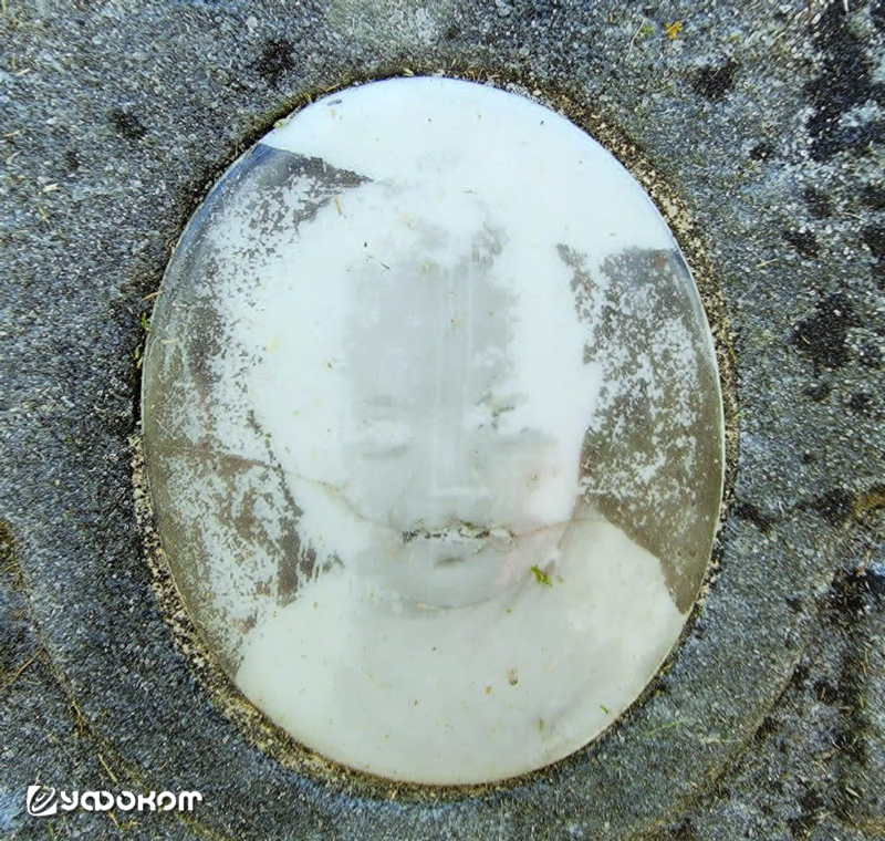 Керамический овал с надгробия Джорджа Элвуда Шарпа крупным планом. Обратите внимание на горизонтальную трещину, пересекающую табличку в области рта ребенка (фото автора).