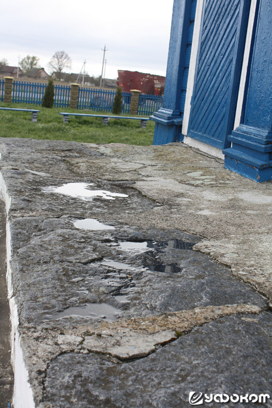 Вода в углублениях на крыльце церкви. Фото автора.