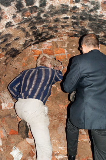 А. Соловьев и А. Супранович расчищают поврежденный вандалами участок подвала бернардинского монастыря.